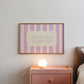 Horizontal art print with hand-painted pink and cream vertical stripes and the quote "Spark joy or get out" in pink cursive script inside a rounded cream panel at the centre.