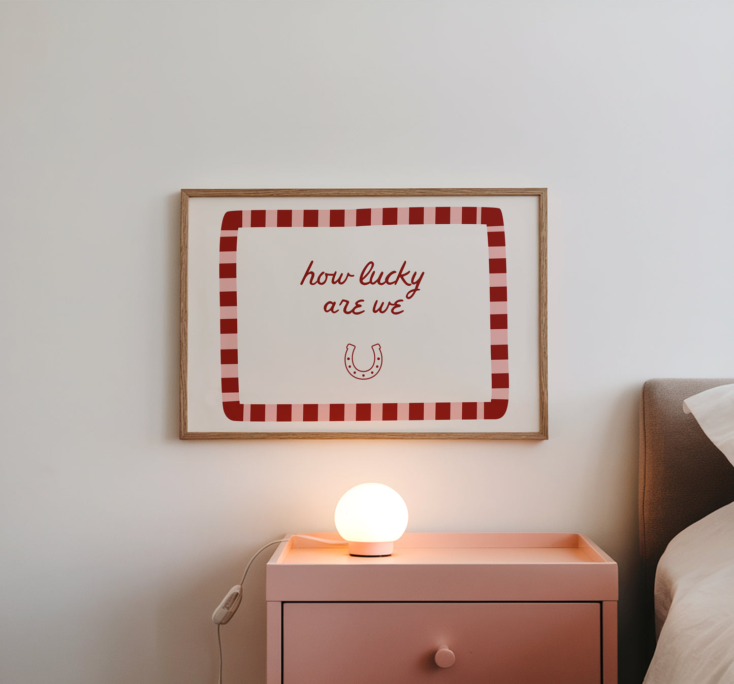 White print with a red and pink striped border featuring the handwritten quote 'how lucky are we' and a horseshoe illustration