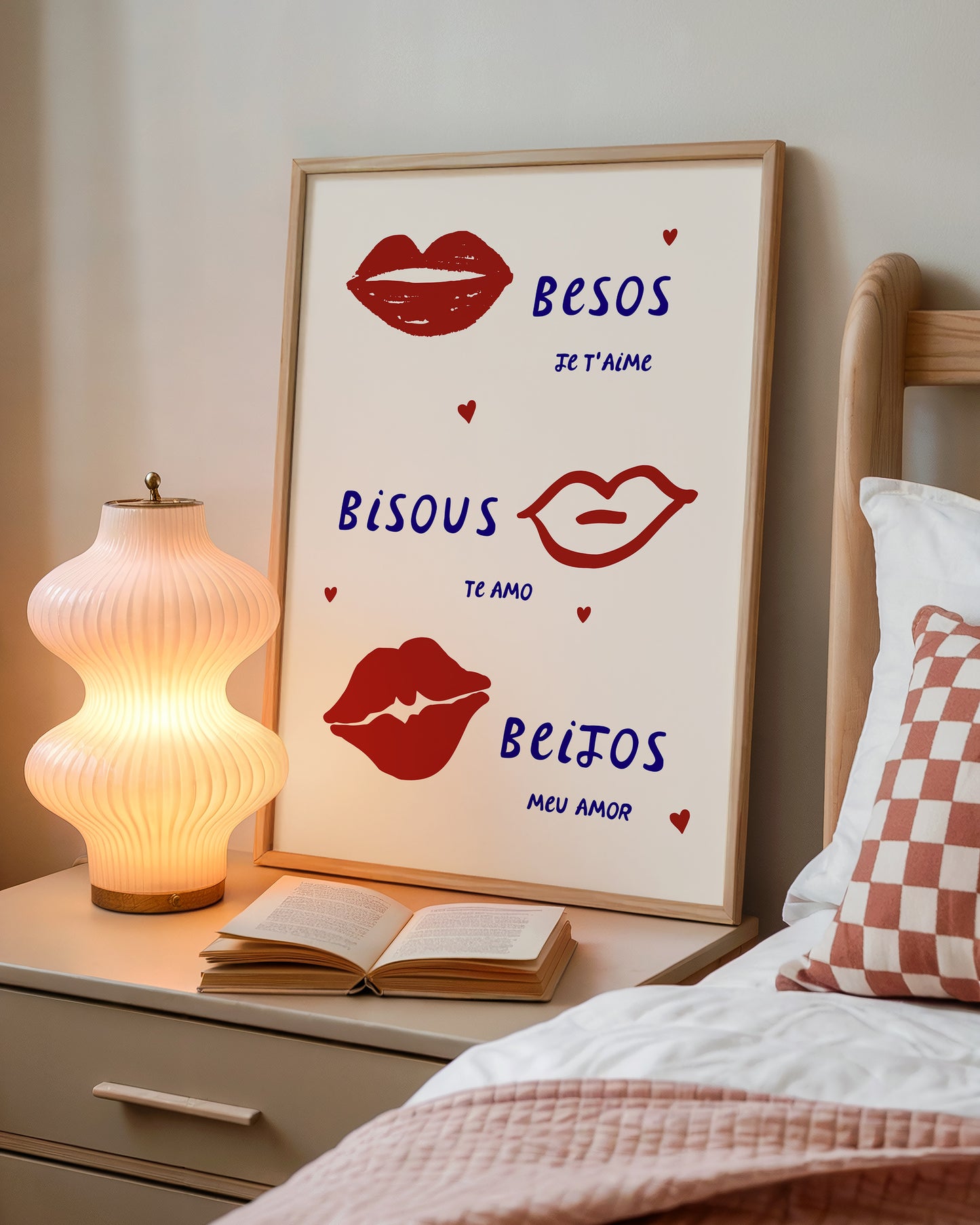 Cream print with three illustrated red lips paired with "Besos," "Bisous," and "Beijos" in navy lettering, with small red hearts scattered throughout