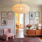 Set of 10 coastal watercolor prints in pink and blue: "Wild Like the Sea" beside a spiral shell illustration, "Stay Wild Ocean Child" in bold blue lettering, "Sea La Vie" in pink stamped typography, a mermaid lounging in a martini glass, pink starfish and seashell illustrations, a woman in a shell headdress, a beach umbrella watercolor, and "Meet me by the sea" in postcard-style script.