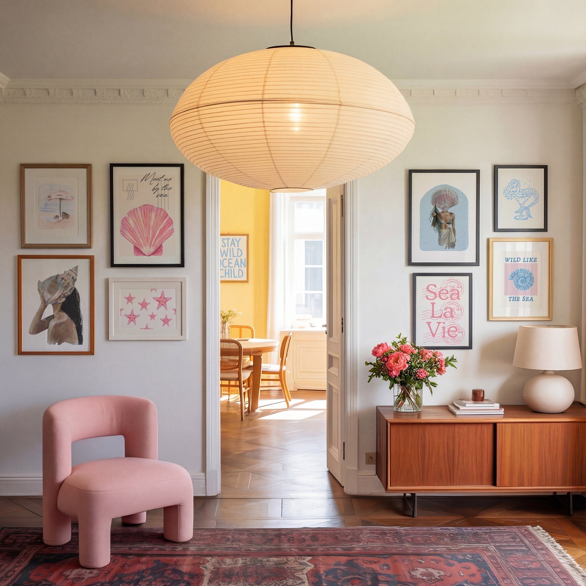 Set of 10 coastal watercolor prints in pink and blue: "Wild Like the Sea" beside a spiral shell illustration, "Stay Wild Ocean Child" in bold blue lettering, "Sea La Vie" in pink stamped typography, a mermaid lounging in a martini glass, pink starfish and seashell illustrations, a woman in a shell headdress, a beach umbrella watercolor, and "Meet me by the sea" in postcard-style script.