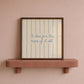 Cream print with thin vertical blue stripes and a hand-lettered quote in blue cursive script