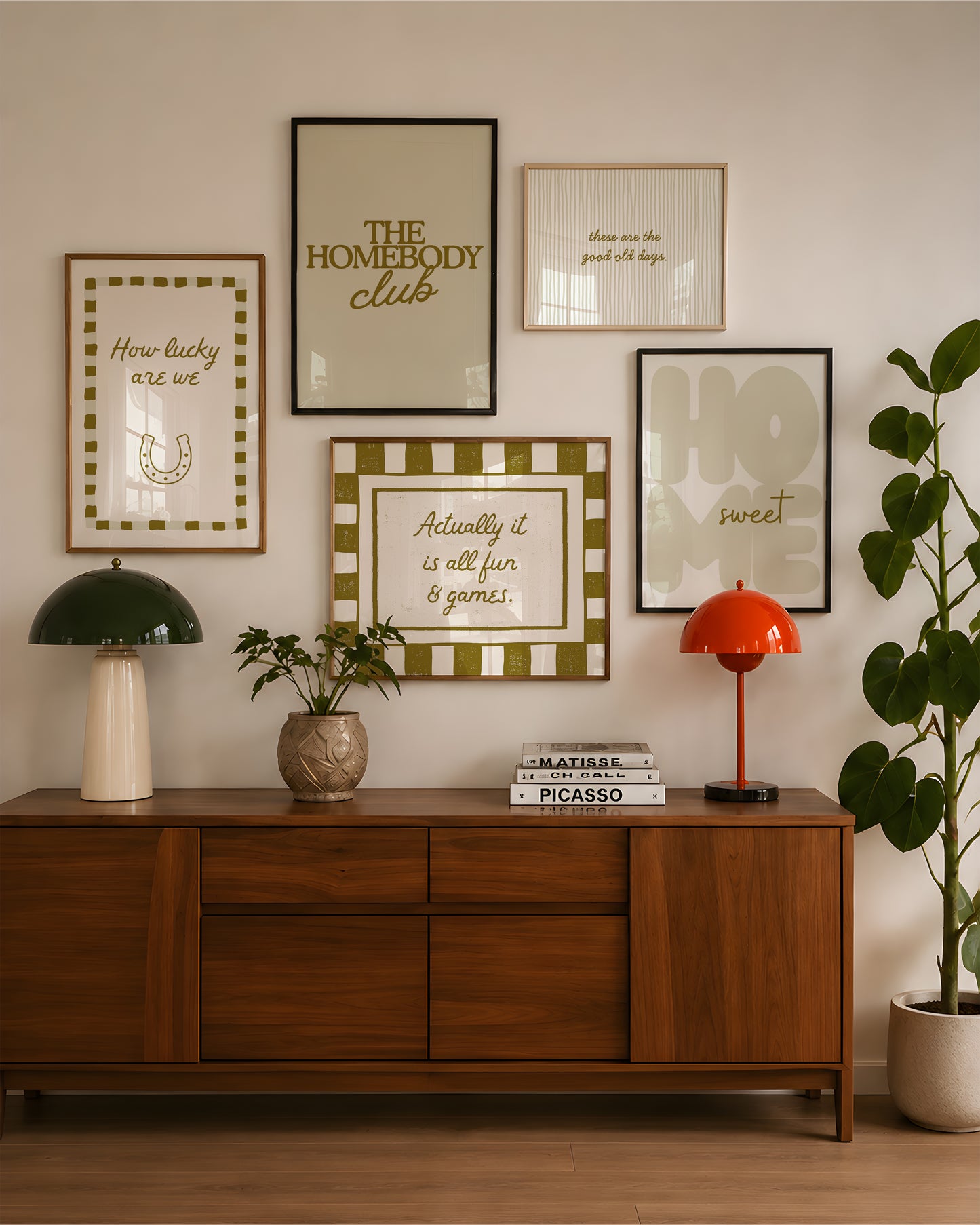 Set of five olive and cream prints including a checkered 'Actually it is all fun & games' print, a horseshoe 'How lucky are we' print, 'The Homebody Club', a striped 'good old days' print, and bubble-letter 'Home sweet'