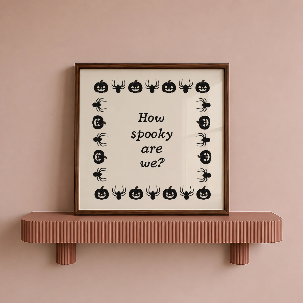 Square digital print with a cream background bordered by alternating black pumpkin and spider illustrations, framing the hand-lettered phrase "How spooky are we?" in black script.
