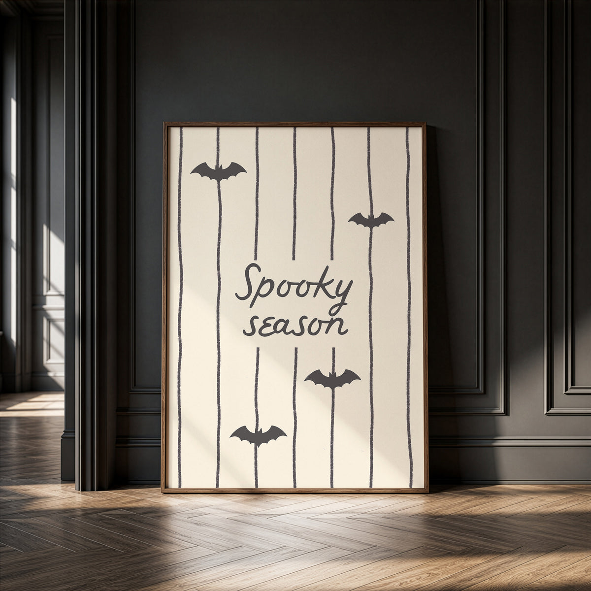 Portrait digital print with a tan and cream striped background featuring the hand-lettered phrase "Spooky season" in black script, accented with three minimalist black bat silhouettes.