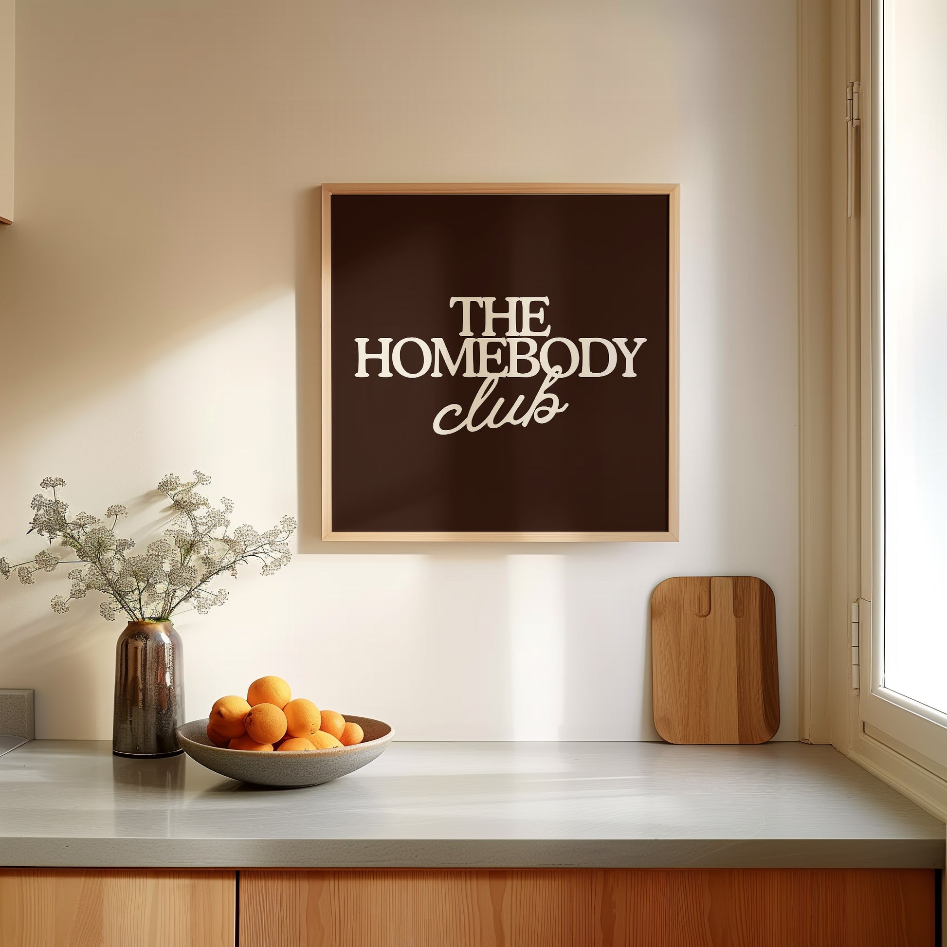 Dark brown print with "The Homebody Club" in bold cream serif and script typography