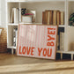 Horizontal wall print with soft pink wavy vertical stripes and bold red rounded typography reading LOVE YOU BYE! in the bottom corner