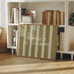 Horizontal print with olive green and cream hand-painted vertical stripes and the quote "it really is all fun & games" in white typewriter-style lettering across the center.