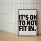 Square cream wall print with bold oversized black chunky typography reading It's Ok To Not Fit In on a clean white background