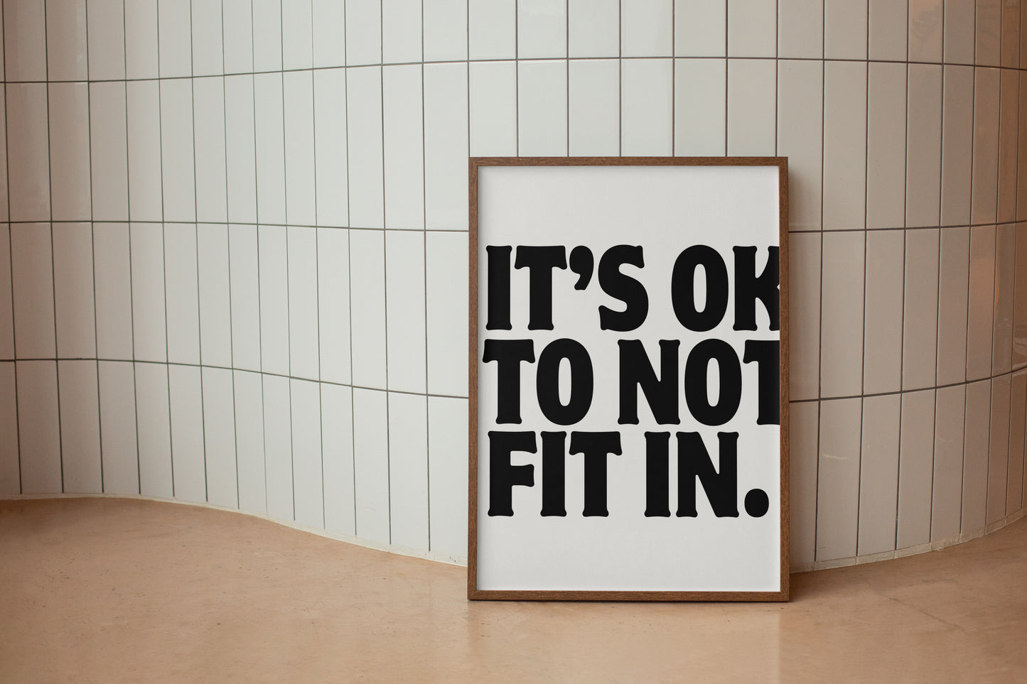 Square cream wall print with bold oversized black chunky typography reading It's Ok To Not Fit In on a clean white background