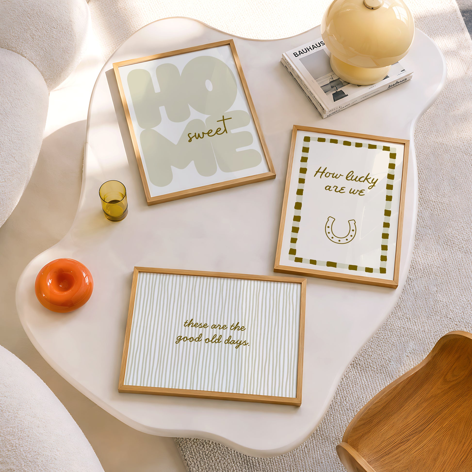 Set of five olive and cream prints including a checkered 'Actually it is all fun & games' print, a horseshoe 'How lucky are we' print, 'The Homebody Club', a striped 'good old days' print, and bubble-letter 'Home sweet'
