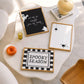 Set of 3 Halloween prints: a black background print with cartoon ghosts reading "We're so happy you're here," a checkered "Spooky Season" print, and a minimalist black spider illustration on a cream background.