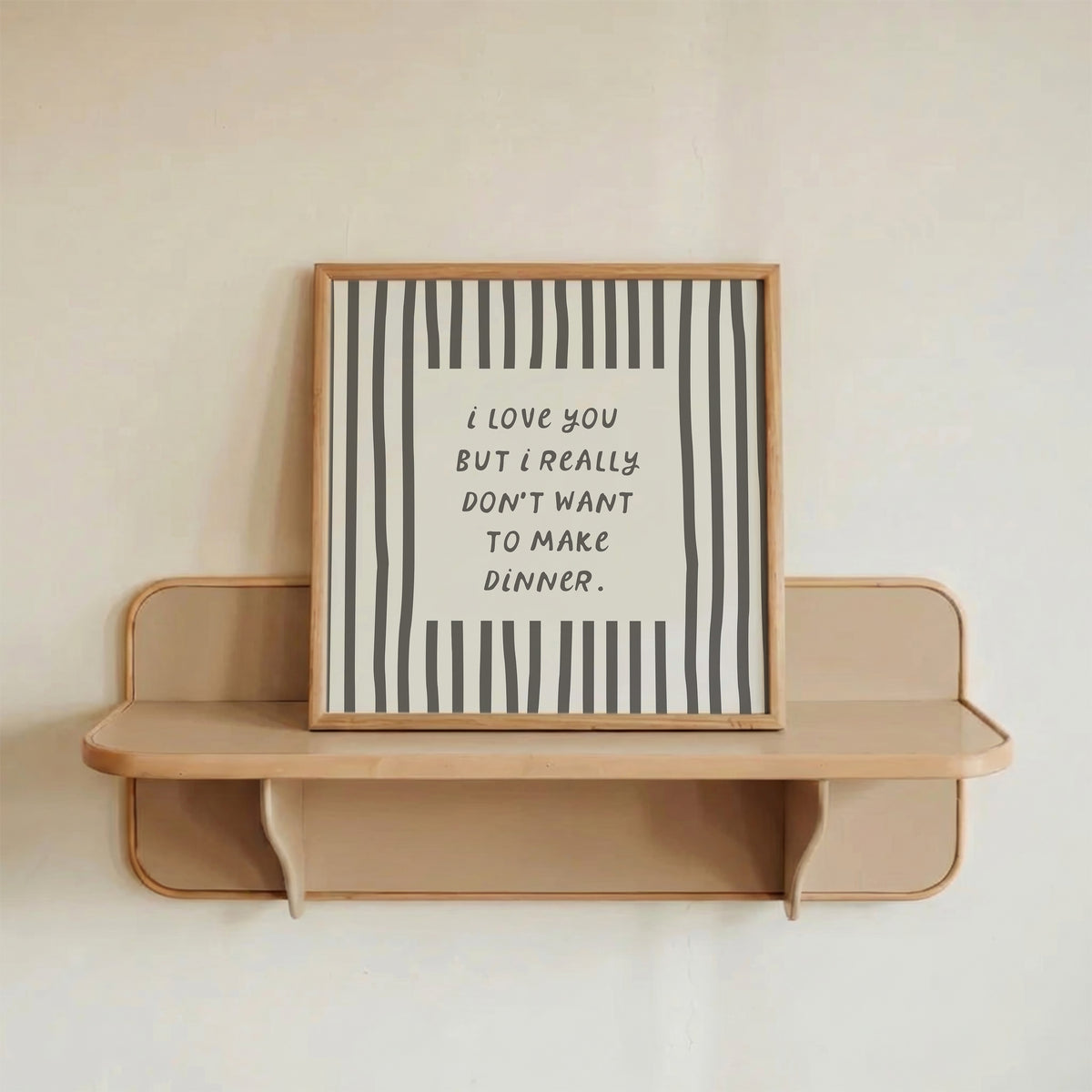 Square print with bold black and white vertical stripes framing the quote "i love you but i really don't want to make dinner" in dark gray block lettering.
