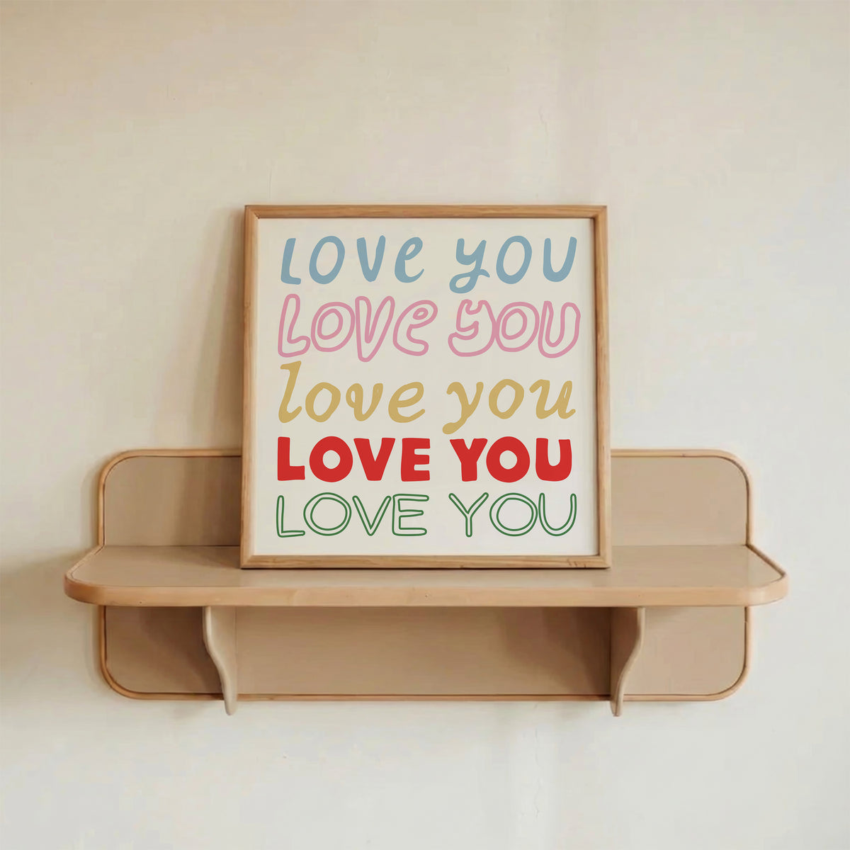 Square print with the words "Love You" repeated five times in different colors, fonts, and styles — blue, pink, gold, red, and green — stacked on a cream background.