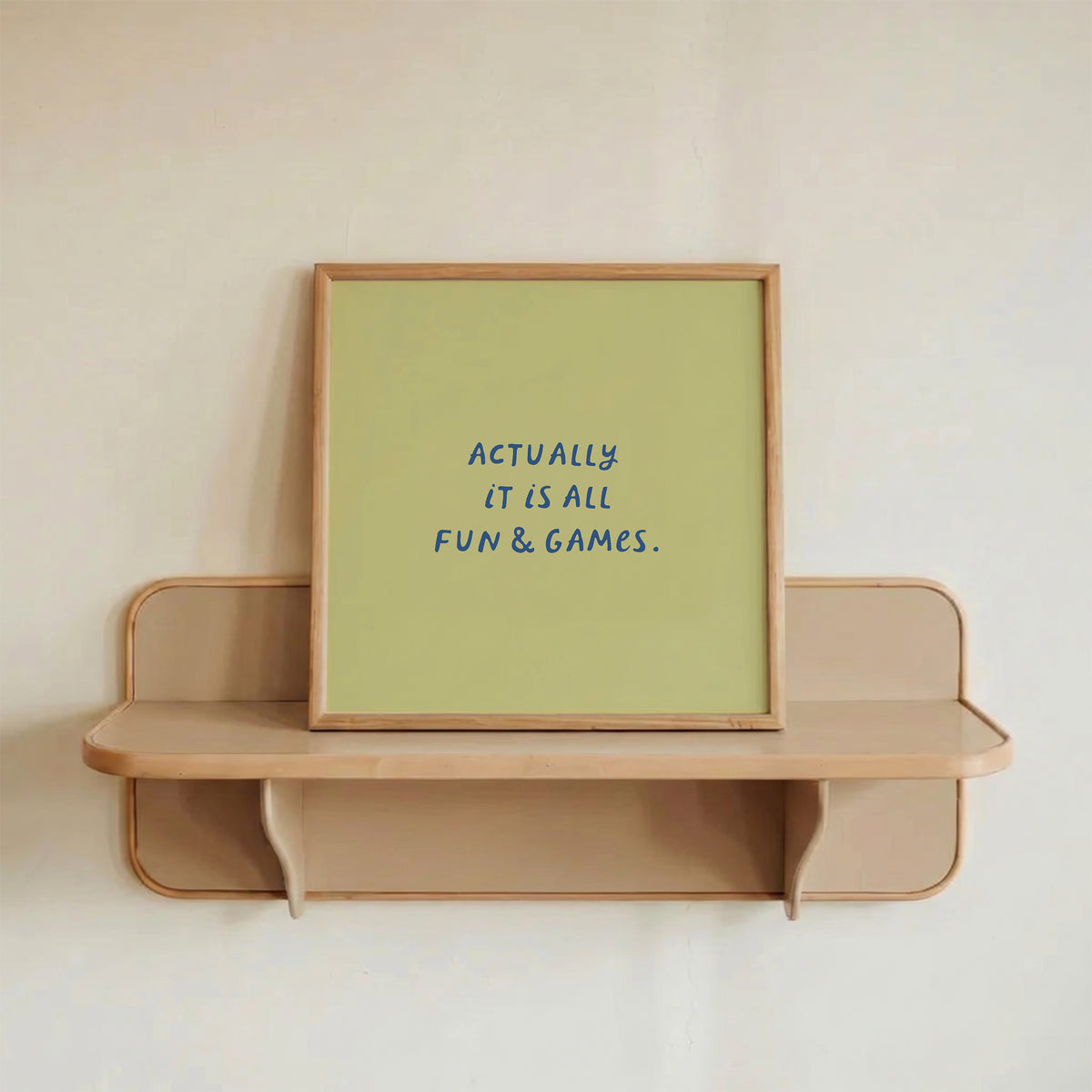 Square print with an olive green background and the quote "Actually it is all fun & games." in bold blue hand-lettered type.