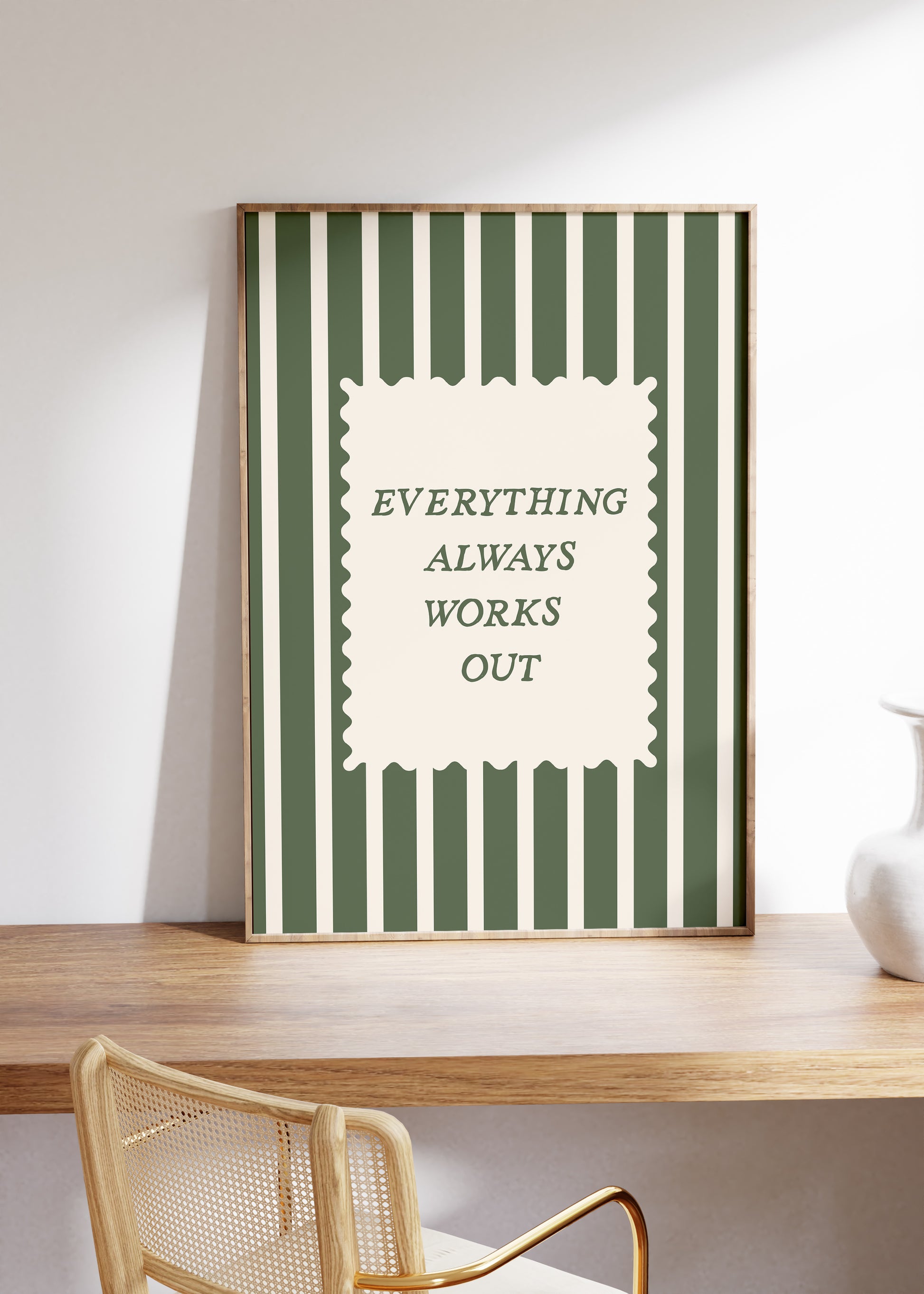 Vertical wall print with bold forest green vertical stripes and a cream scalloped text box reading Everything Always Works Out in dark green serif typography