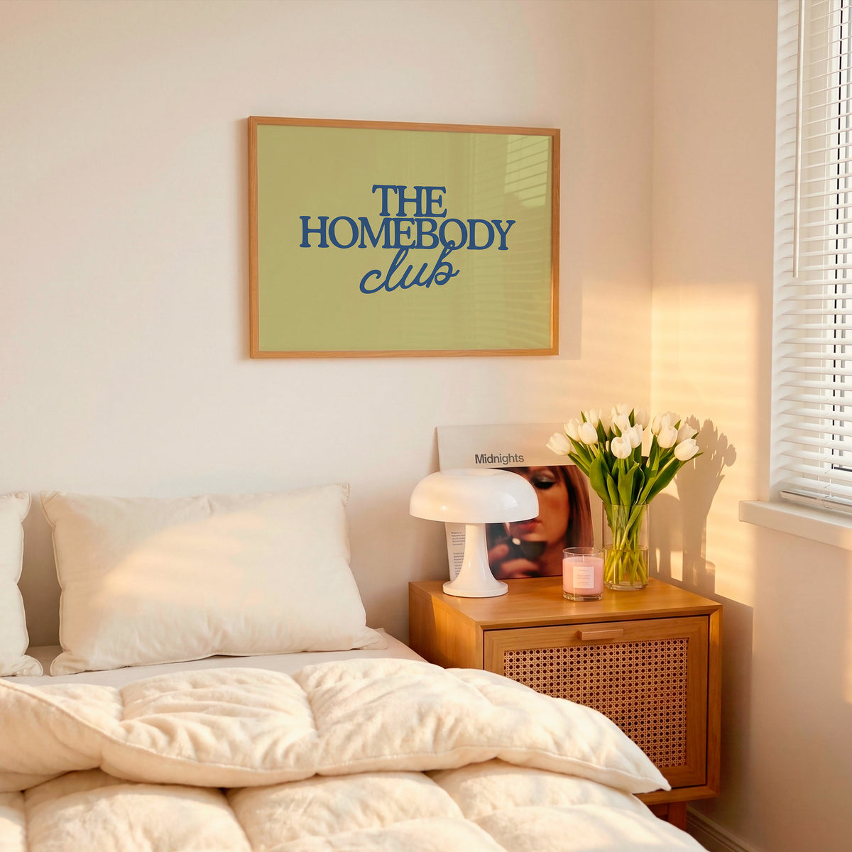 Rectangular landscape digital print with an olive-green background featuring "THE HOMEBODY" in bold blue serif type stacked above "club" in blue cursive script, centered typography layout.