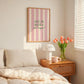 Print with soft pink hand-painted brush stroke stripes and the quote "What's the best that can happen" in script lettering.