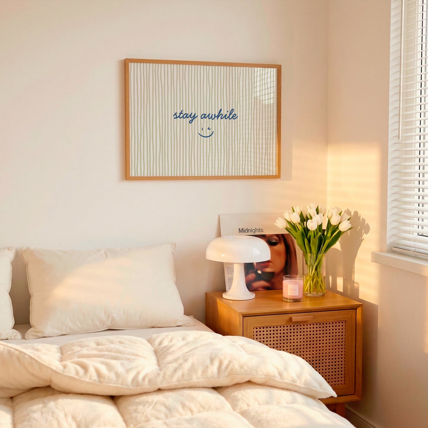 Horizontal print with thin hand-painted tan and cream vertical stripes, the quote "stay awhile" in navy cursive script, and a small hand-drawn smiley face beneath it.