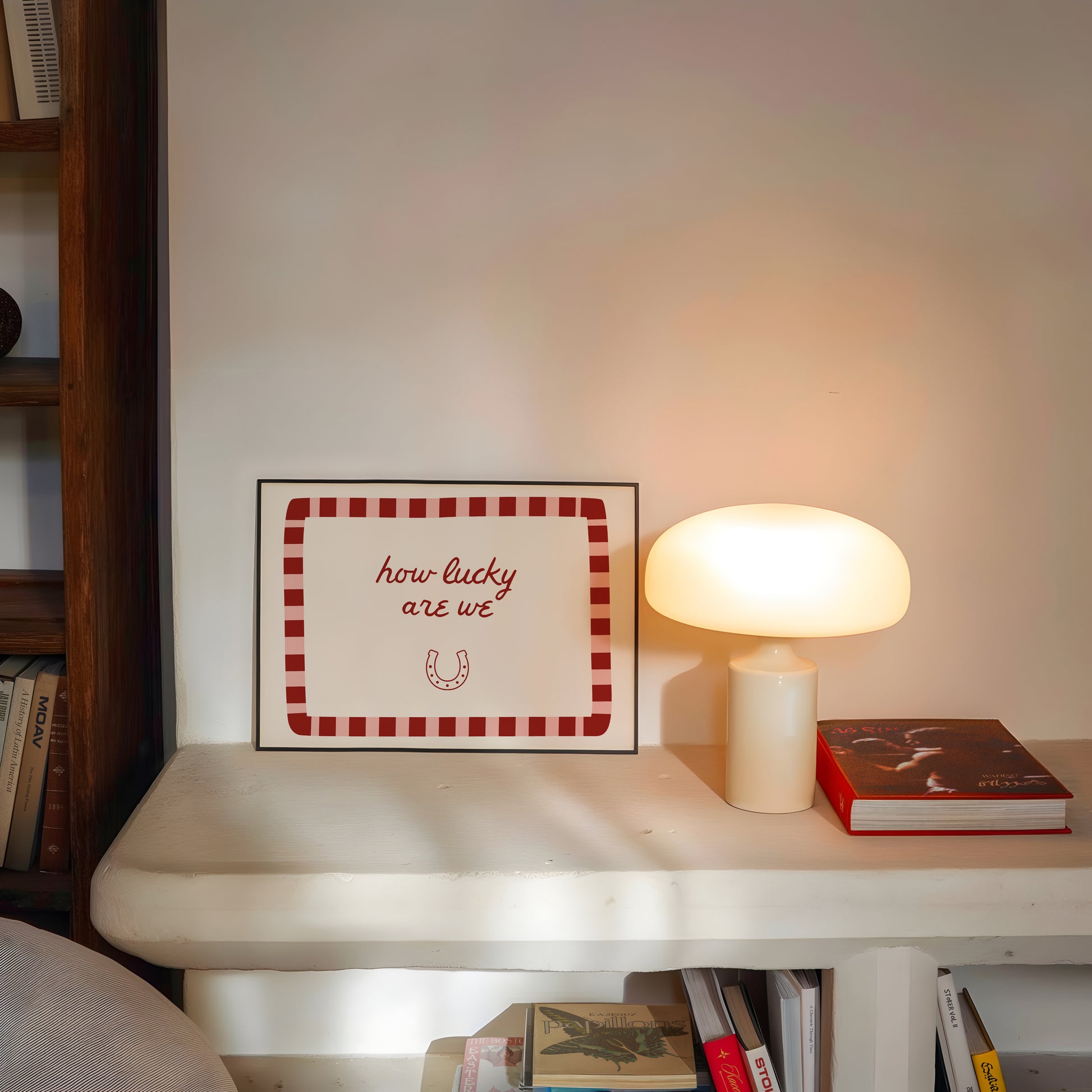 White print with a red and pink striped border featuring the handwritten quote 'how lucky are we' and a horseshoe illustration