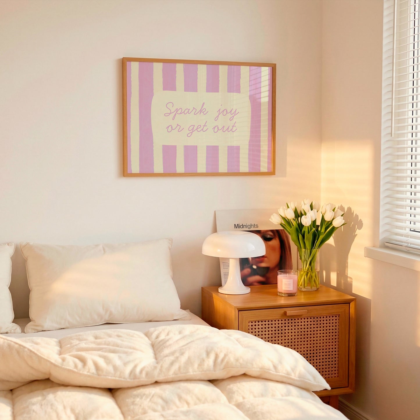 Horizontal art print with hand-painted pink and cream vertical stripes and the quote "Spark joy or get out" in pink cursive script inside a rounded cream panel at the centre.