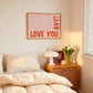 Horizontal wall print with soft pink wavy vertical stripes and bold red rounded typography reading LOVE YOU BYE! in the bottom corner