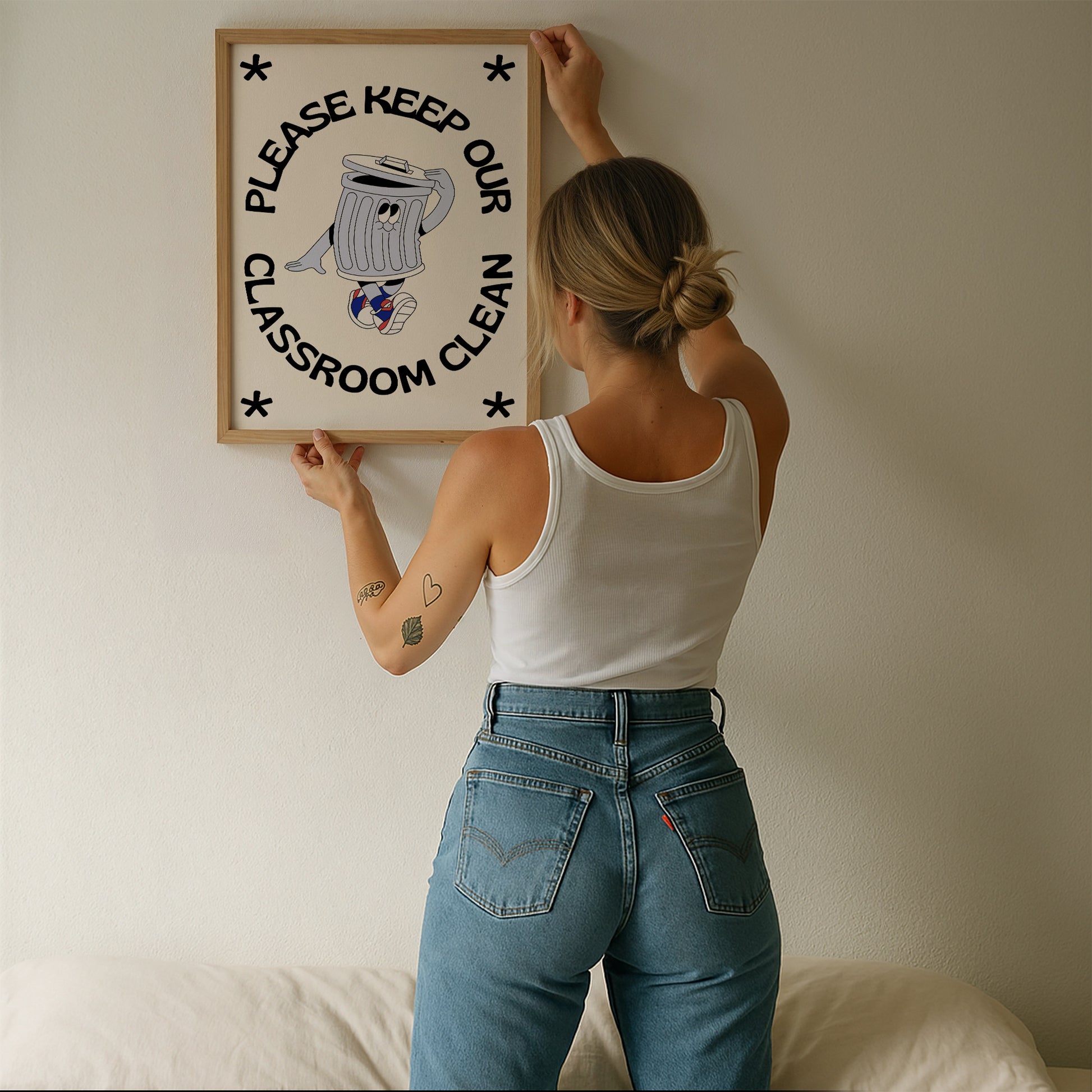 Vertical cream wall print with bold arched black typography reading Please Keep Our Classroom Clean surrounding a retro cartoon trash can character wearing sneakers with asterisk corner details