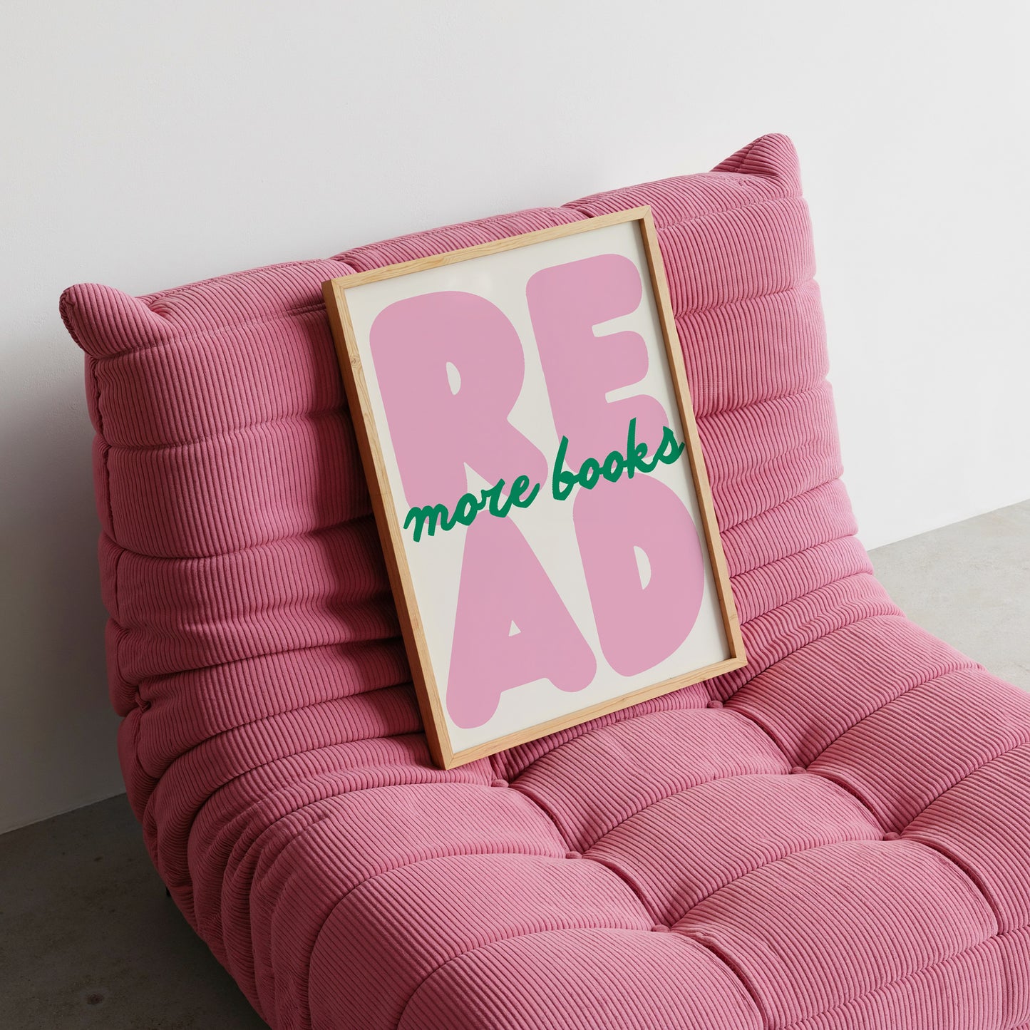 Vertical print with the word "READ" in oversized pink bubble letters and "more books" in green cursive script layered across it, on a white background.
