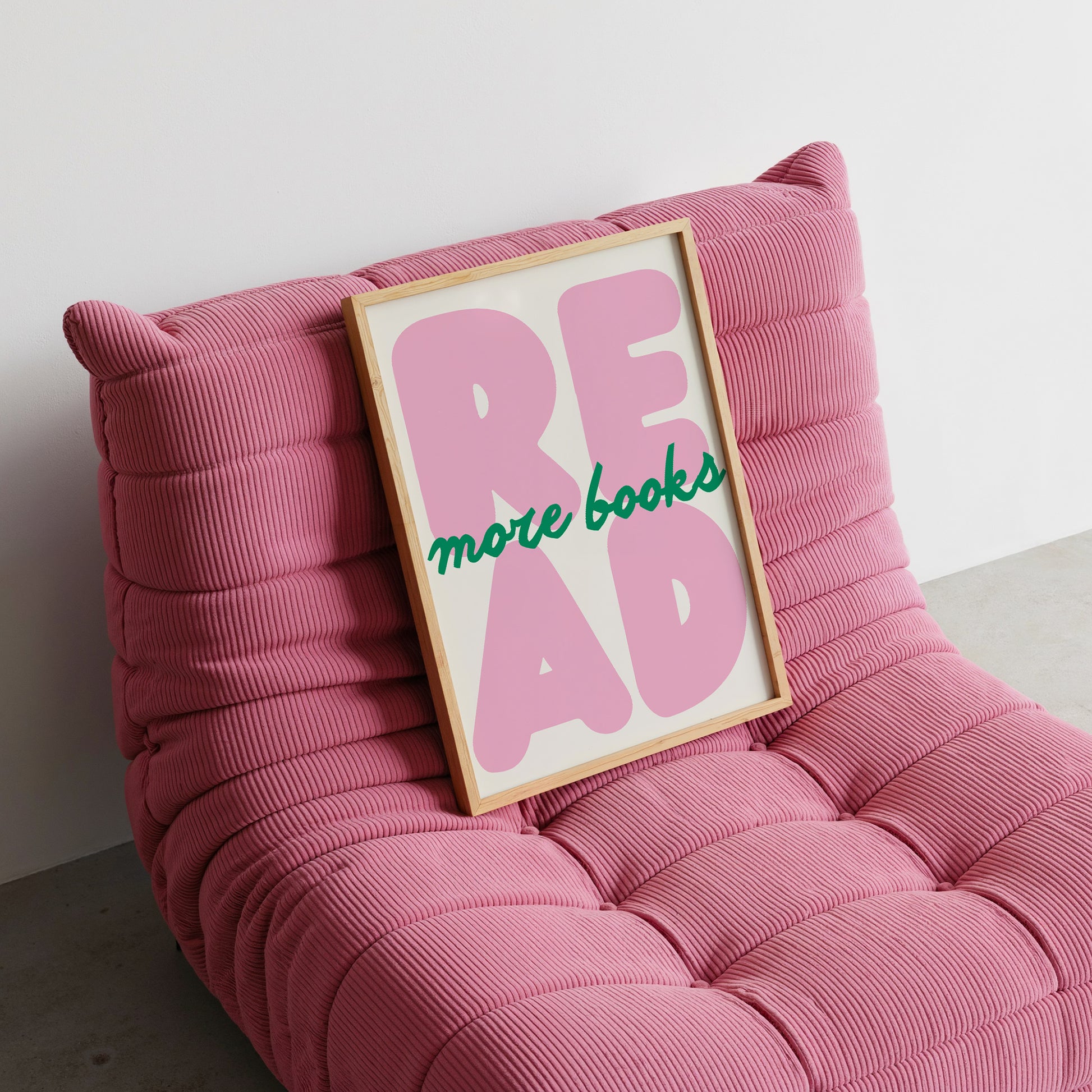 Vertical print with the word "READ" in oversized pink bubble letters and "more books" in green cursive script layered across it, on a white background.
