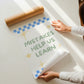 Set of 10 classroom prints in blue, green, and yellow: Yes You Can, Every Voice Matters Here, Slow Down You're Doing Fine, Progress Over Perfection, a starburst Welcome illustration, an Attendance Check print reading Show Up As You Are, Great Minds Grow Here on a checkered background, a smiley face reading Be the Kind Kid, Mistakes Help Us Learn, and Great Things Come to Those Who Try.