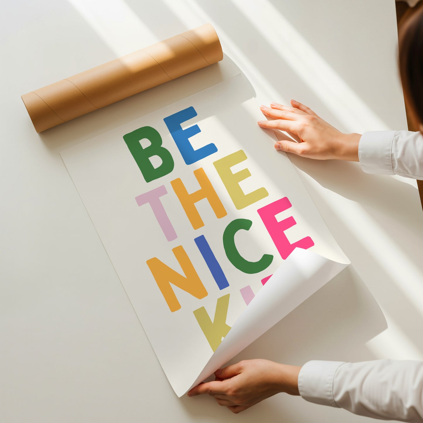 Vertical print with the words "BE THE NICE KID" stacked in large multicolored bubble letters on a cream background in a blue frame.