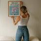 Vertical wall print with bold teal serif typography reading READ TO LEAD above a cheerful retro pink walking book character waving a flag on a teal background