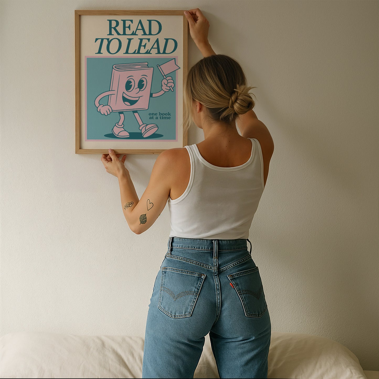 Vertical wall print with bold teal serif typography reading READ TO LEAD above a cheerful retro pink walking book character waving a flag on a teal background