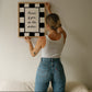 Black and white checkered print with a scalloped border and the handwritten quote "Kisses if you do the dishes" in black script