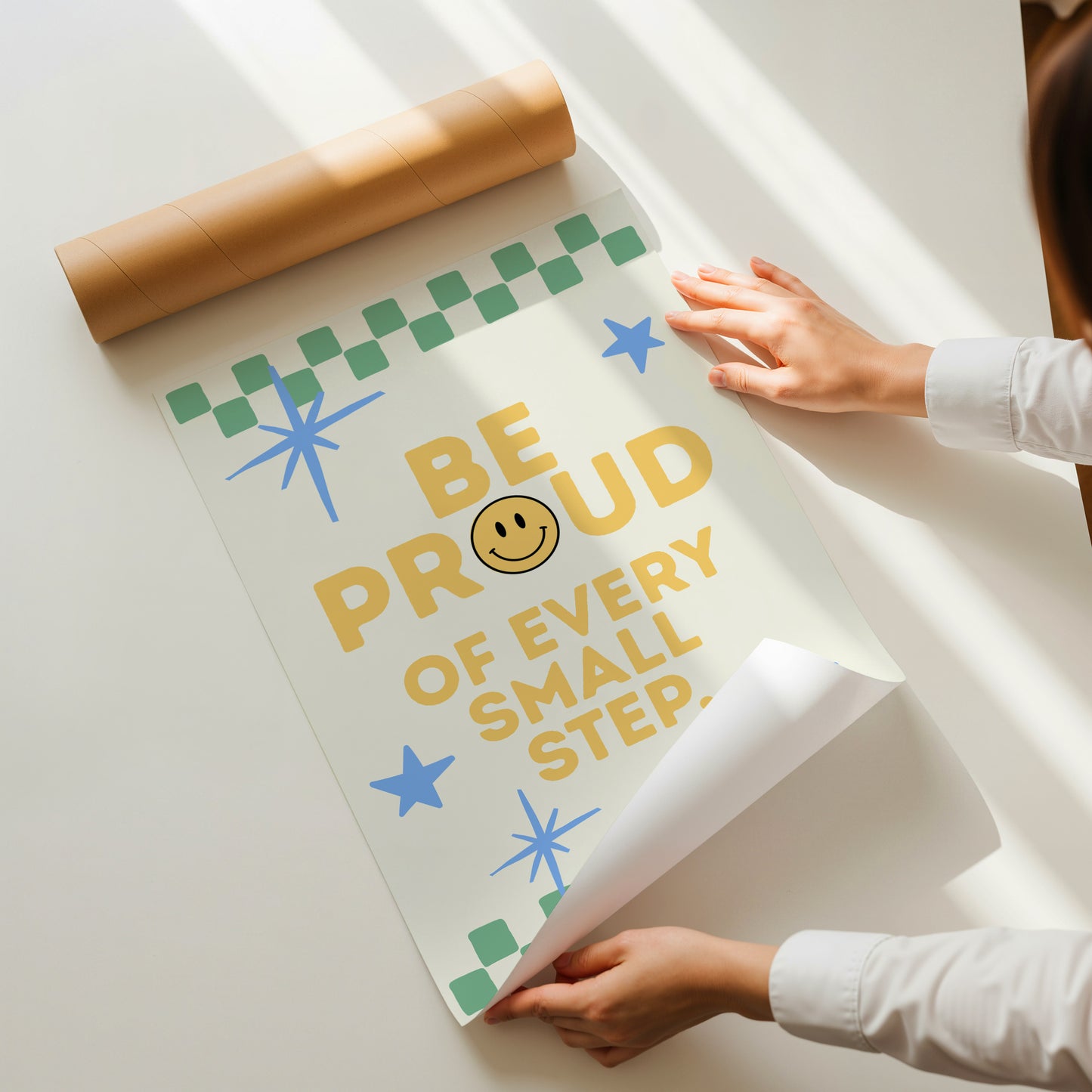 Cream print with a green checkered border, blue stars, and the phrase 'Be Proud of every small step' in yellow lettering with a smiley face replacing the O in Proud