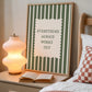 Vertical wall print with bold forest green vertical stripes and a cream scalloped text box reading Everything Always Works Out in dark green serif typography