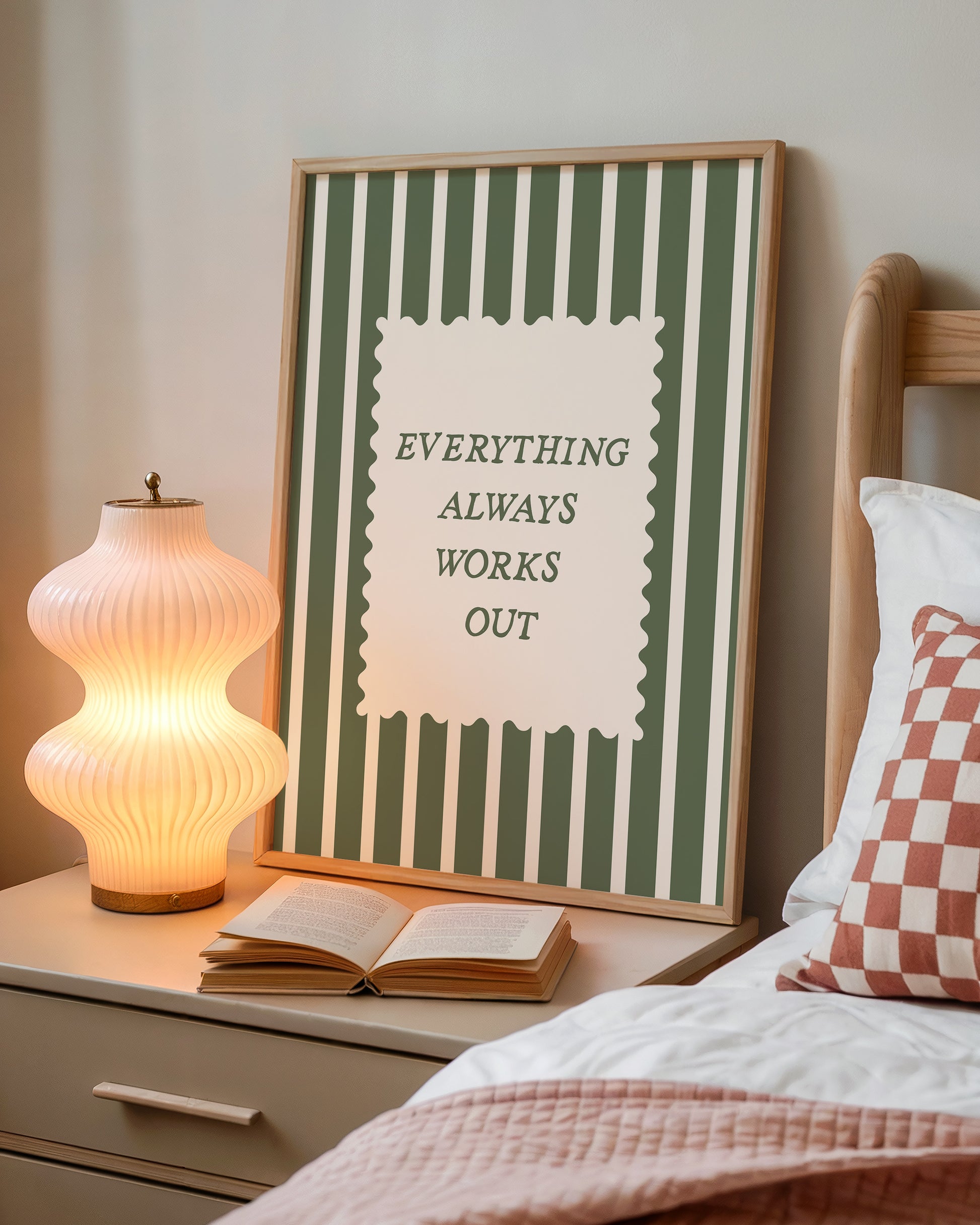Vertical wall print with bold forest green vertical stripes and a cream scalloped text box reading Everything Always Works Out in dark green serif typography
